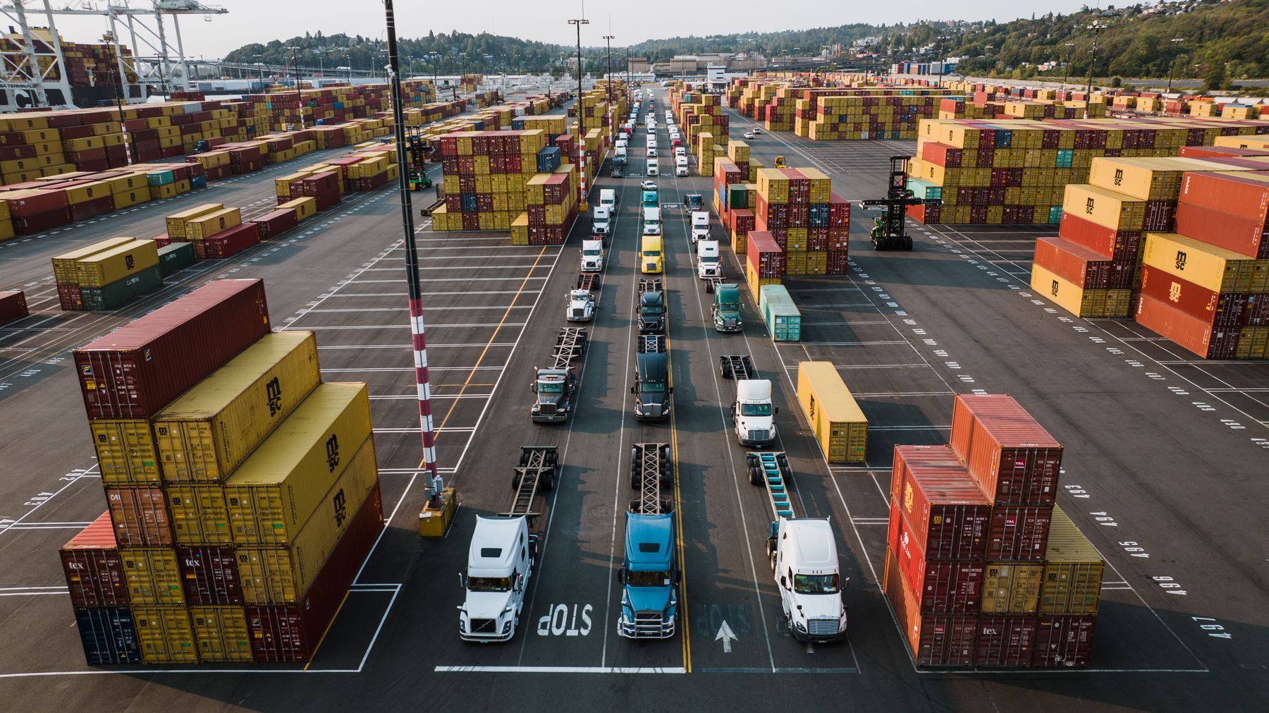 Aerial view of shipping containers and delivery trucks at a working container yard